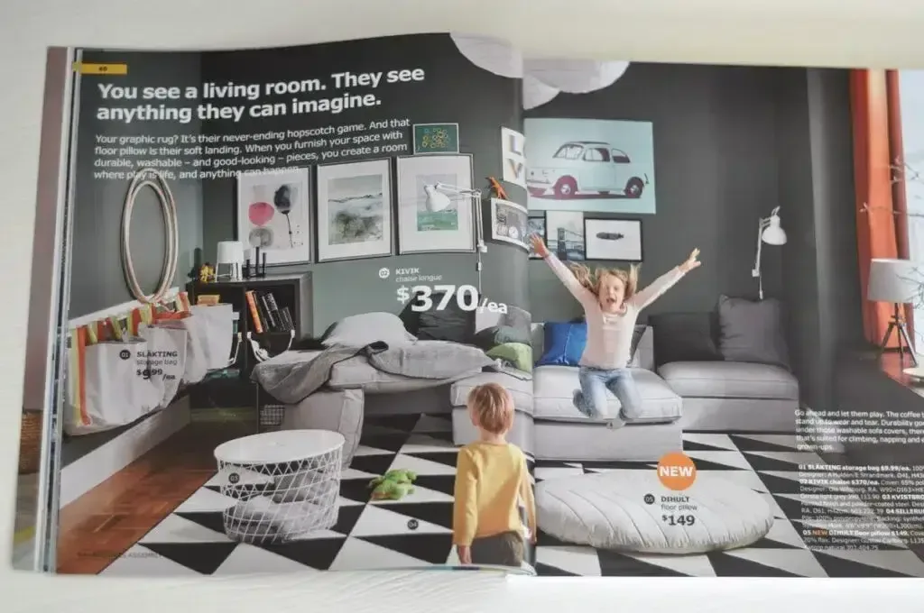 IKEA catalog layout showing a vibrant living room setup with modern furniture, playful decor, and a child jumping on the couch while another child watches. The design promotes imagination and family-friendly spaces, with price tags and product details visible.