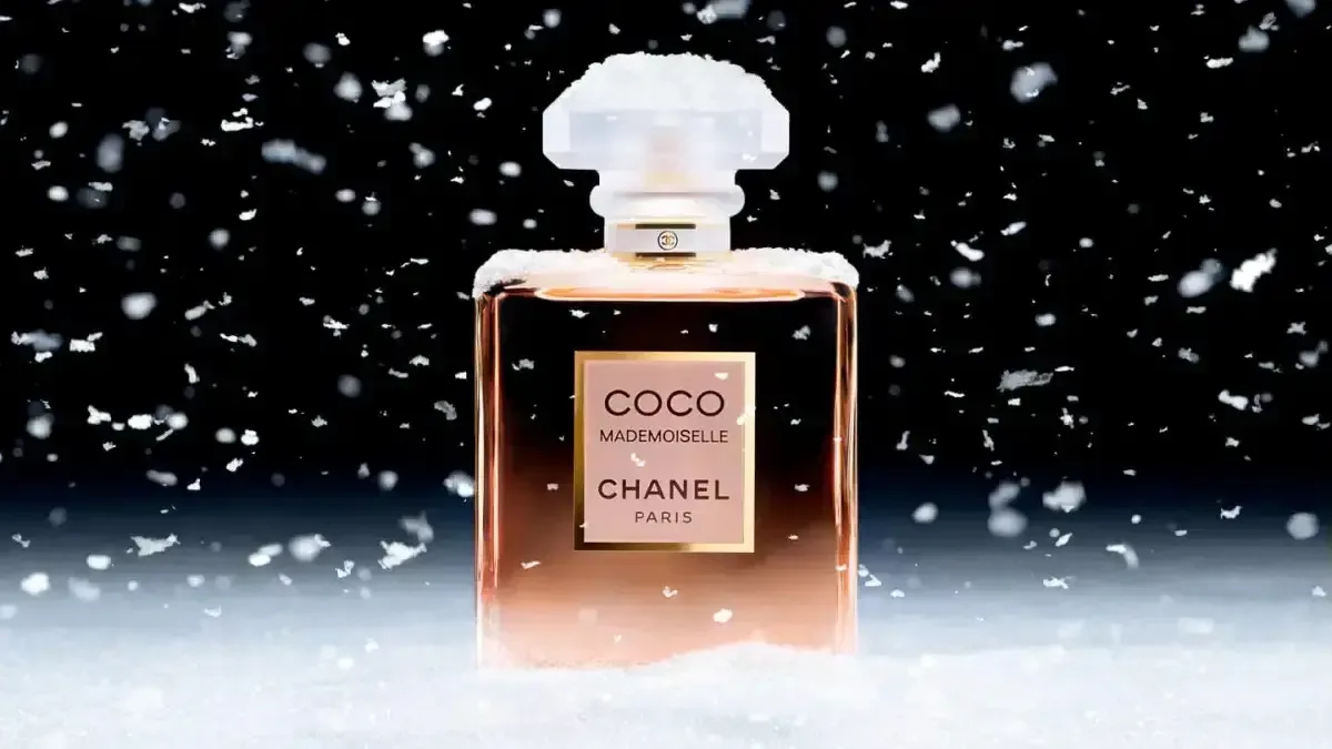 Coco Mademoiselle Chanel perfume bottle in snow with a luxurious and elegant winter theme.