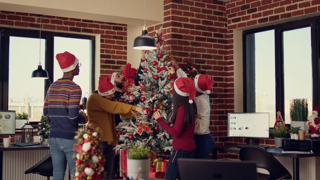 multiethnic team of people putting up the christmas tree
